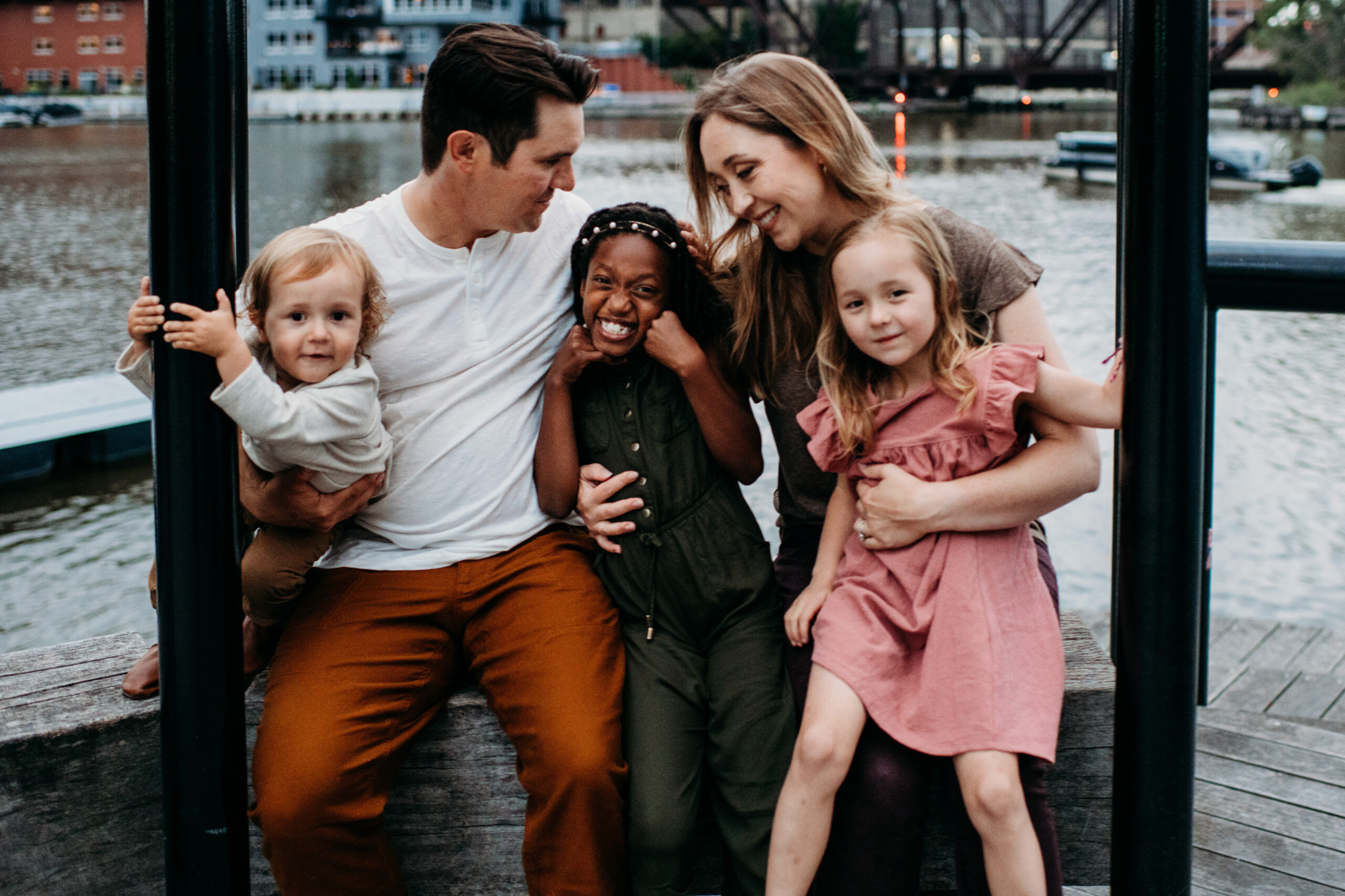 Family of five in neutral colors laughing on the Riverwalk Milwaukee Photo Locations