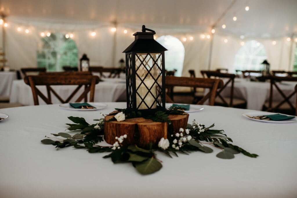 table centerpiece at Wisconsin Wedding venues with a lantern, bark, and eucalyptus